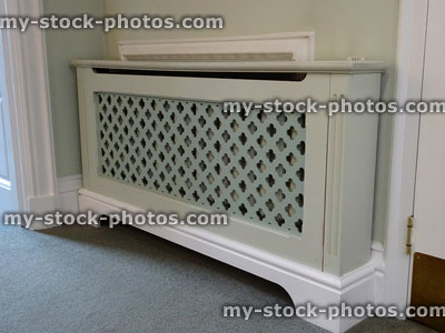 Stock image of wooden radiator cover / cabinet, painted fretwork grille mesh screen