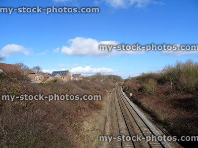 Stock image of railway line / railroad train tracks, passing housing estate