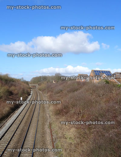 Stock image of railway line / railroad train tracks, running past housing estate