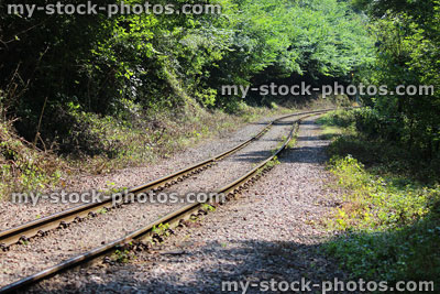 Stock image of railway line covered in gravel, heading through countryside