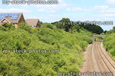 Stock image of railway line / railroad tracks heading through countryside passed houses