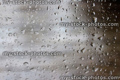 Stock image of rain drops running down window during rainy weather