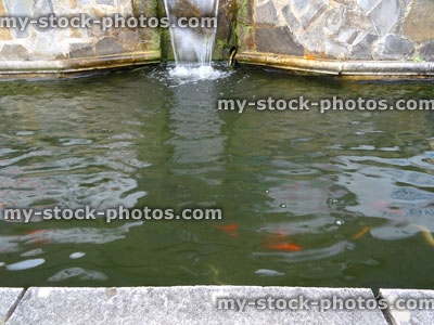 Stock image of rectangular raised formal pond, stone wall, waterfall / water feature