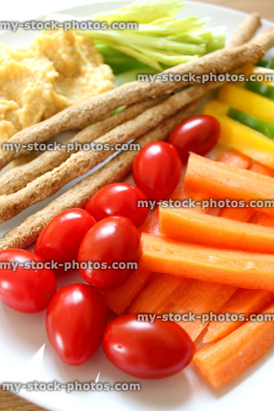 Stock image of healthy raw vegetables, breadsticks, hummus, carrots, plum tomatoes, celery, peppers