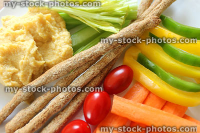 Stock image of healthy raw vegetables, breadsticks, hummus, carrots, cherry tomatoes, celery, peppers