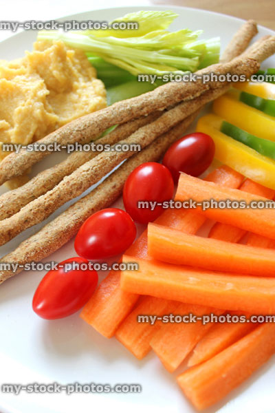 Stock image of healthy raw vegetables, breadsticks, hummus, carrots, plum tomatoes, celery, peppers