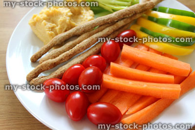 Stock image of healthy lunch, raw vegetables, breadsticks, hummus, carrots, tomatoes, celery, peppers