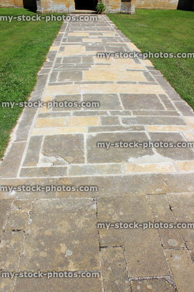 Stock image of re paved pathway of flagstone paving slabs, repaired, new stones