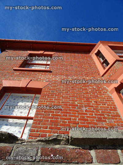 Stock image of red brick terraced house, looking upwards from low angle
