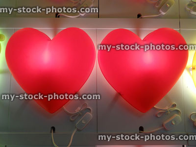 Stock image of two red plastic wall lights shaped as love hearts