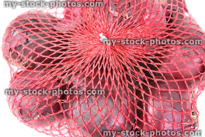 Stock image of dried purple / red onions, sold bagged in netting