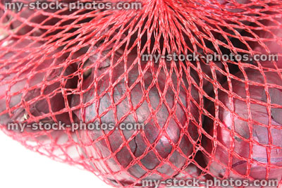 Stock image of dried purple / red onions, net bag in supermarket