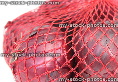 Stock image of dried purple / red onions, net / string bag, supermarket