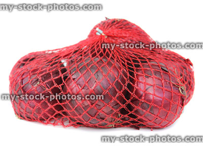 Stock image of dried purple / red onions, net onion bag, white background