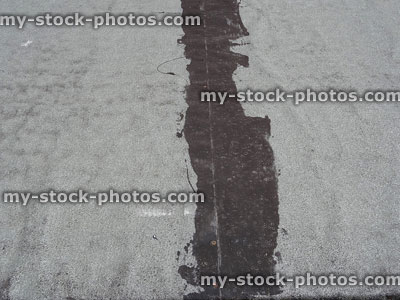 Stock image of flat roof felt repaired, patched up with tar