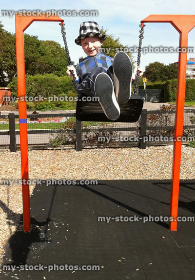 Stock image of boy on a swing, swinging high into air