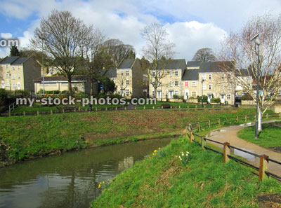 Stock image of river, pathway, trees and modern townhouses