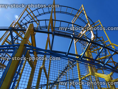 Stock image of light railroad tracks of yellow rollercoaster theme park ride