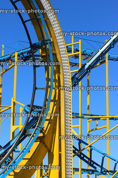 Stock image of rollercoaster ride at theme park, blue sky background