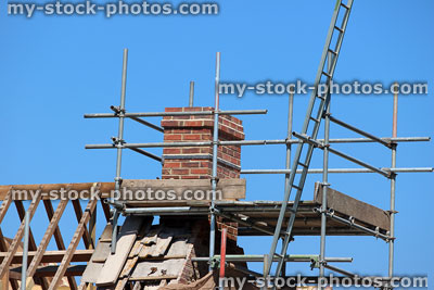 Stock image of scaffolding around chimney and exposed roofing, replacing roof tiles