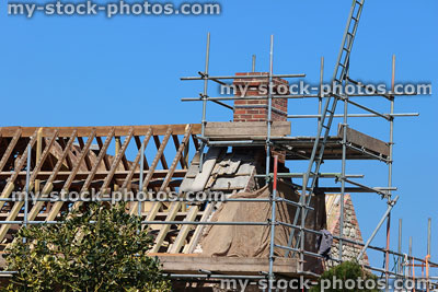 Stock image of roof being replaced, scaffolding around roofing and chimney