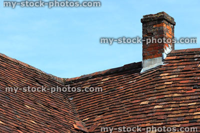 Stock image of historic tiled roof and chimney with handmade red clay tiles