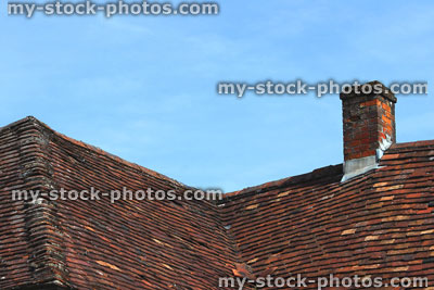 Stock image of historic tiled roof and chimney with handmade red clay tiles