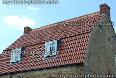 Stock image of historic cottage roof with red clay tiles and dormer windows