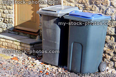 Stock image of grey rubbish bins by back door, recycling wheelie bins