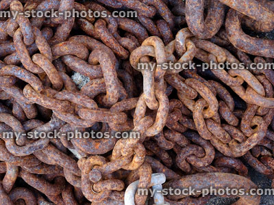 Stock image of rusty chain links in pile at fishing boat harbour