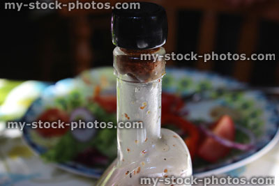 Stock image of homemade salad dressing in glass vinaigrette bottle