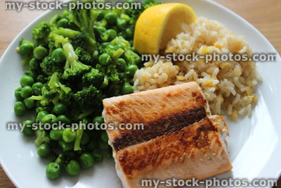 Stock image of fried salmon fillet, brown rice, peas, broccoli, healthy meal diet