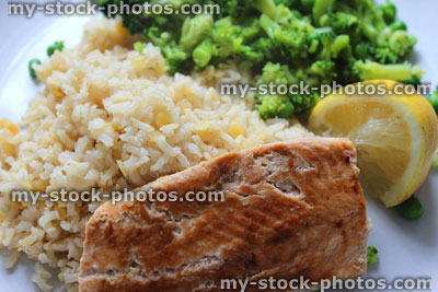 Stock image of fried salmon fillet, brown rice, peas, broccoli, healthy meal diet