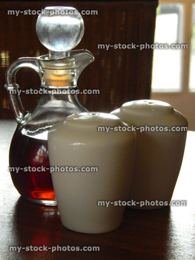 Stock image of cruet set, glass vinegar bottle, china salt and pepper pots / shakers