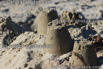 Stock image of round bucket and spade sandcastles on seaside beach