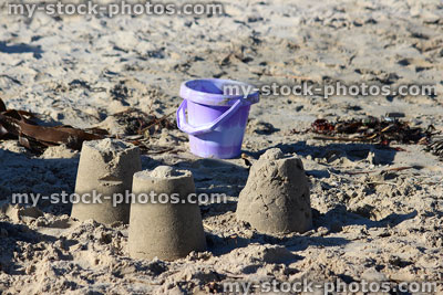 Stock image of round sandcastles built by children on sandy beach