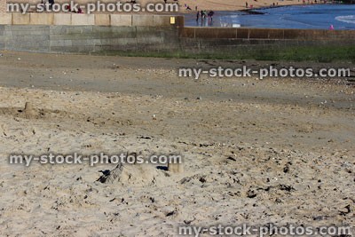 Stock image of seaside summer scene with holidaymakers, families, sandcastles, beach