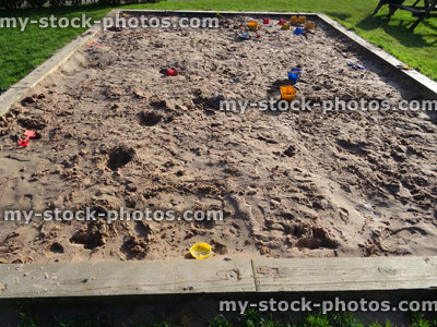 Stock image of raised sandpit in playground, bucket and spade, sandcastles