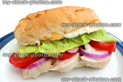 Stock image of chicken salad sandwich / sub, chicken breast, tomatoes, lettuce, red onion