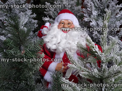 Stock image of toy Santa Claus figure with fake Christmas trees