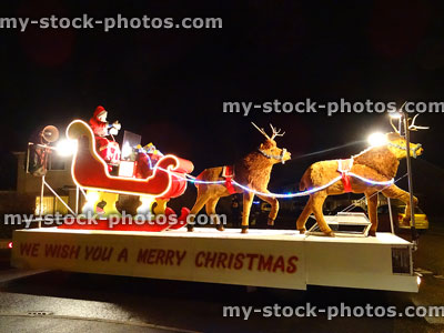 Stock image of waving Santa Claus on carnival float, sitting in sleigh