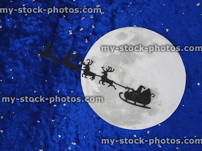 Stock image of moon with Santa Claus sleigh and reindeer silhouette
