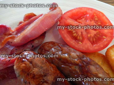 Stock image of fried breakfast with sausages, bacon, hash brown, tomato