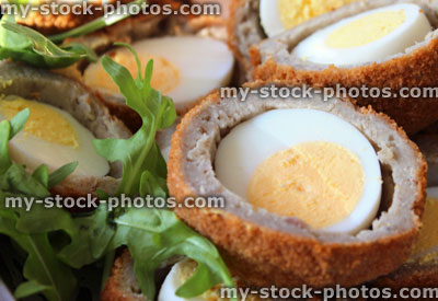 Stock image of homemade Scotch eggs sliced in half, party food