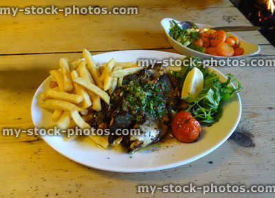 Stock image of grilled sea bass, chips / French fried, side salad, vegetables