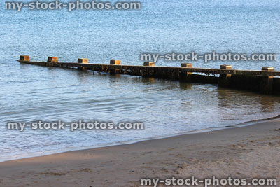 Stock image of wooden seaside groyne on sandy beach, sea defence