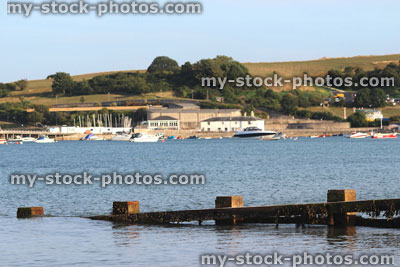 Stock image of wooden seaside groyne, sandy beach, sea defence, town, yachts