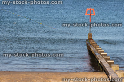 Stock image of wooden seaside groyne on sandy beach, sea defence