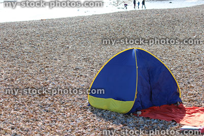 Stock image of popup beach shelter / tent on pebbles, seaside holiday