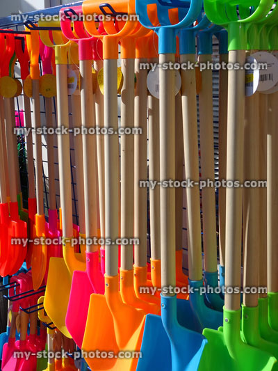 Stock image of rainbow coloured seaside buckets and spades in beach shop